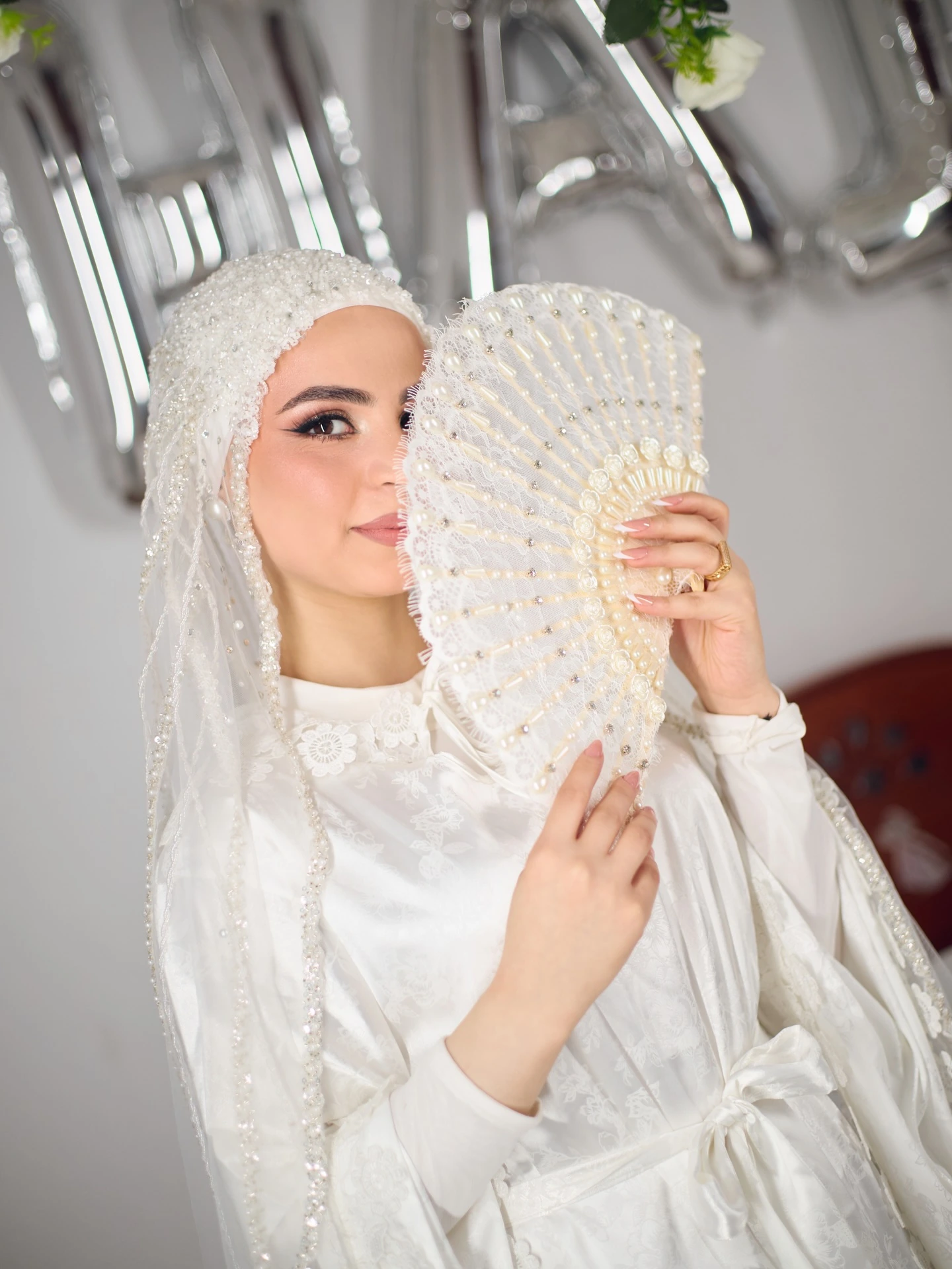 العروسة ماسكة مروحة بيضا